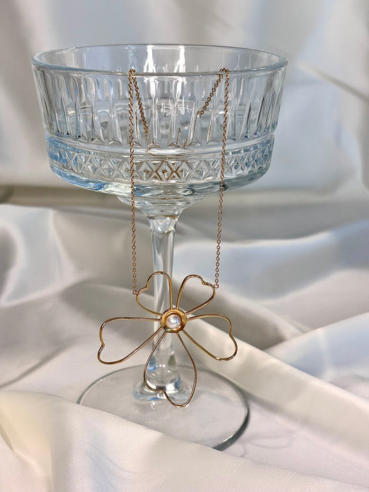 Collier doré avec fleur ajourée et perle centrale